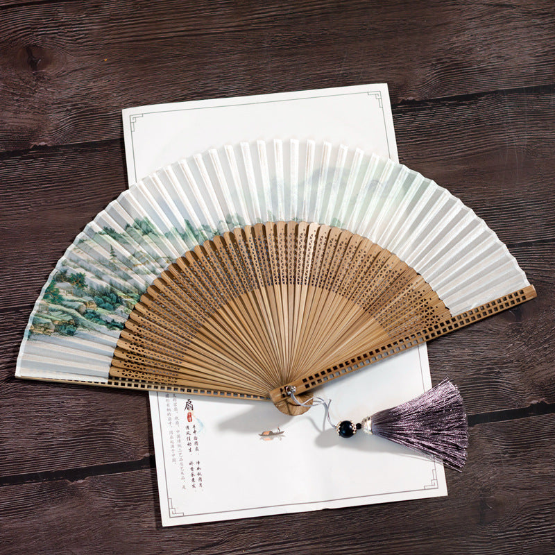 优雅的竹制扇子,带有传统山水画和流苏,适合汉服造型
